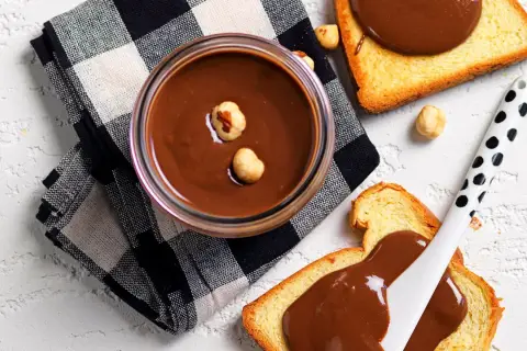 Crema di nocciole fatta in casa, vellutata e invitante, su fette di pane tostato. Un piacere da gustare!